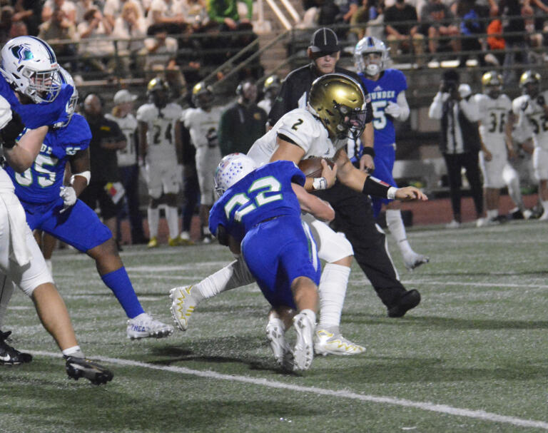 Mountain View’s Porter Drake (22) tackles Evergreen quarterback Jayden Crace during Evergreen’s 20-14 win over Mountain View at McKenzie Stadium on Friday, Sept. 30, 2022.