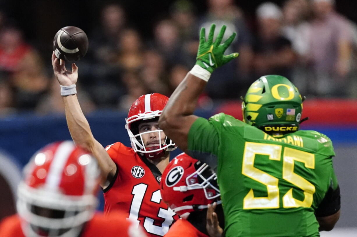 Georgia quarterback Stetson Bennett (13) throws under pressure from Oregon defensive lineman Taki Taimani (55) in the first half of an NCAA college football game game Saturday, Sept. 3, 2022, in Atlanta.