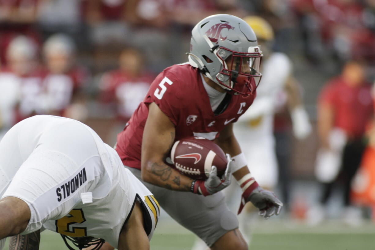 Washington State wide receiver Lincoln Victor avoids a tackle by Idaho linebacker Fa'Avae Fa'Avae during the first half Saturday in Pullman. The Union High grad who was named one of the Cougars six captains for the season caught three passes for 38 yards in Washington State's 24-17 victory.