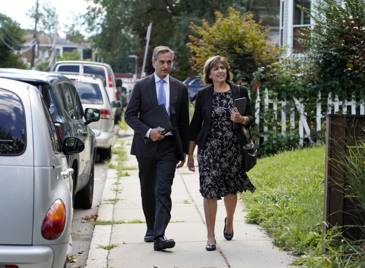 Dan Sideris and his wife, Carrie Sideris, of Newton, Mass., walk along a sidewalk Sept. 1 as they return to door-to-door visits as Jehovah's Witnesses in Boston.