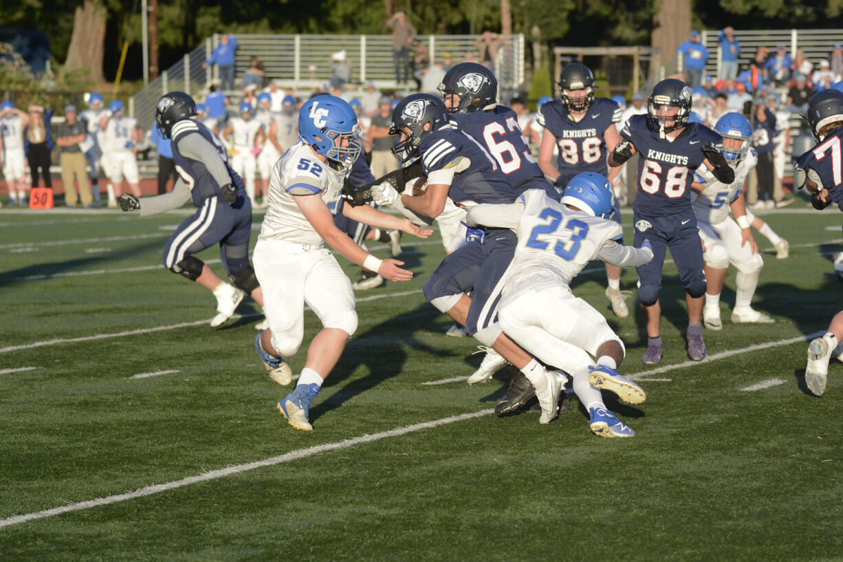 La Center’s Adam White (52) and Jalen Ward (23) try to bring down King’s Way Christian’s Ryan Charlton during La Center’s 46-0 win over King’s Way Christian in a Trico League game on Thursday, Sept. 29, 2022.