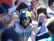 Seattle Mariners' Ty France is congratulated by teammates after hitting a three-run home run against the Los Angeles Angels during the seventh inning of a baseball game in Anaheim, Calif., Monday, Sept. 19, 2022.