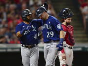 Seattle Mariners' Cal Raleigh, front right, is congratulated by Carlos Santana after hitting three-run home run off Cleveland Guardians relief pitcher Bryan Shaw during the sixth inning of a baseball game Friday, Sept. 2, 2022, in Cleveland.