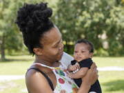 Venessa Aiken holds her son Jahzir Robinson, five weeks old, outside their home Sunday, Aug. 21, 2022, in Orlando, Fla.