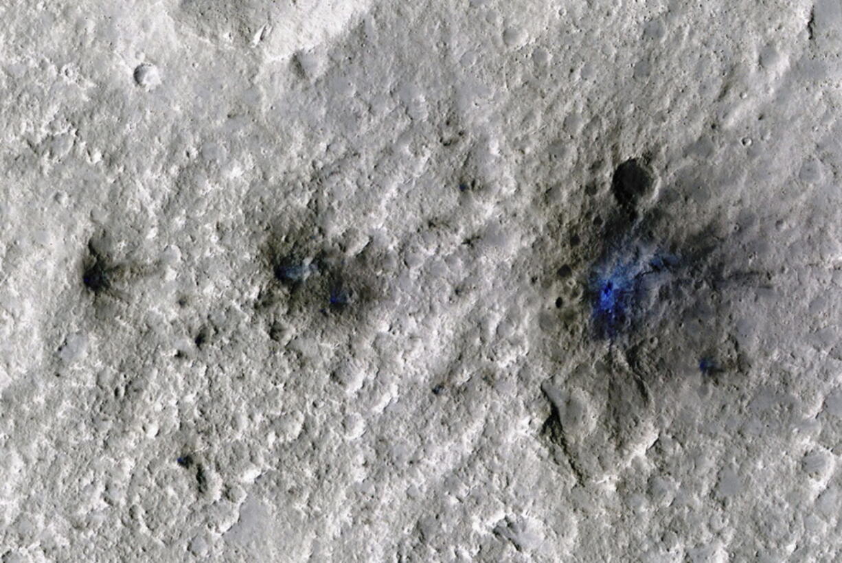 This undated photo released by NASA shows craters that were formed by a Sept. 5, 2021, meteoroid impact on Mars, the first to be detected by NASA's InSight. Taken by NASA's Mars Reconnaissance Orbiter, this enhanced-color image highlights the dust and soil disturbed by the impact in blue in order to make details more visible to the human eye. NASA lander on Mars has captured the vibrations and sounds of four meteorites striking the planet's surface. Scientists reported Monday, Sept. 19, 2022, that Mars InSight detected seismic and acoustic waves from a series of impacts in 2020 and 2021.