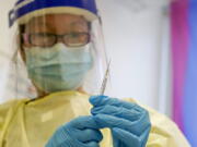 FILE - A physician assistant prepares a syringe with the monkeypox vaccine for a patient during a vaccination clinic Friday, Aug. 19, 2022, in New York. The disease's spread is slowing but the virus is unlikely to be eliminated because it is widespread enough that spread of the disease is expected to continue, the Centers for Disease Control and Prevention said in late September 2022.