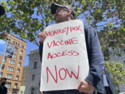 FILE - A man holds a sign urging increased access to the monkeypox vaccine during a protest in San Francisco on July 18, 2022. With monkeypox cases subsiding in Europe and parts of North America, many scientists say now is the time to prioritize stopping the virus in Africa.