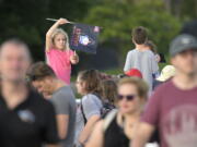 A child waves a souvenir flag while waiting on the Max Brewer Bridge to view the launch on Pad 39B for the Artemis I mission to orbit the moon at the Kennedy Space Center, Monday, Aug. 29, 2022, in Titusville, Fla. The launch was scrubbed. (AP Photo/Phelan M.