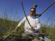 Ryan White, front, and Darold Madigan harvest wild rice on Leech Lake in Minnesota, Sunday, Sept. 11, 2022. White, who has been ricing for three decades, says the beds are "continually shrinking," which endangers the wild rice's spiritual and economic gifts.