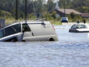 FILE - Several abandoned vehicles sit in flood waters caused by Hurricane Matthew at the intersection of John and Benton streets in Goldsboro, N.C., Monday, Oct. 10, 2016. Nearly six years after extreme rainfall and flooding from Hurricane Matthew damaged many North Carolina homes, some homeowners are still left waiting on repairs. A new bipartisan General Assembly committee tasked with investigating the delays holds its first meeting Wednesday, Sept. 14, 2022, on the four-year anniversary of when Hurricane Florence made landfall in North Carolina.