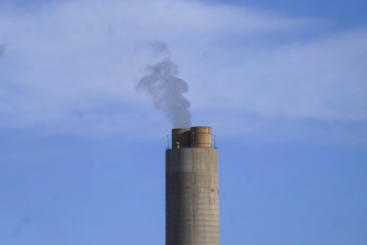 FILE - A smokestack stands at a coal plant on Wednesday, June 22, 2022, in Delta, Utah. On Monday, Sept. 19, the world's first public database of fossil fuel production, reserves and emissions launches.  It shows that the United States and Russia have enough fossil fuel reserves to exhaust the world's remaining carbon budget to stay under 1.5 degrees Celsius warming.