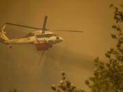 A helicopter provides air support for fighting the Bolt Creek Fire in Washington state on Saturday, Sept. 10, 2022.