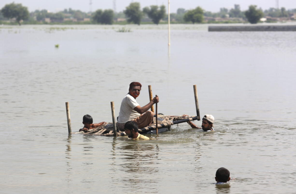 People use cot to salvage belongings from their nearby flooded home caused by heavy rain in Jaffarabad, a district of Pakistan's southwestern Baluchistan province, Saturday, Sep. 3, 2022. The homeless people affected by monsoon rains triggered devastating floods in Pakistan get enhancing international attention amid growing numbers of fatalities and homeless families across the country as the federal planning minister appealed the international community for immense humanitarian response for 33 million people.