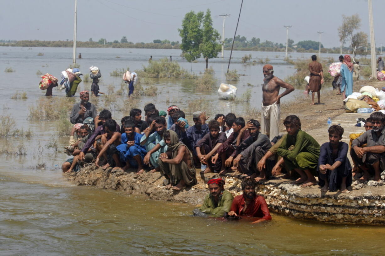 Victims of heavy flooding from monsoon rains wait to receive relief aid from the Pakistani Army in the Qambar Shahdadkot district of Sindh Province, Pakistan, Friday, Sept. 9, 2022. U.N. Secretary-General Antonio Guterres appealed to the world for help for cash-strapped Pakistan after arriving in the country Friday to see the climate-induced devastation from months of deadly record floods.