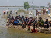 Victims of heavy flooding from monsoon rains wait to receive relief aid from the Pakistani Army in the Qambar Shahdadkot district of Sindh Province, Pakistan, Friday, Sept. 9, 2022. U.N. Secretary-General Antonio Guterres appealed to the world for help for cash-strapped Pakistan after arriving in the country Friday to see the climate-induced devastation from months of deadly record floods.