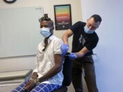 In this photo provided by the San Francisco AIDS Foundation, a person receives the Monkeypox vaccine at the San Francisco AIDS Foundation Monkeypox vaccine clinic in San Francisco. Two biopharmaceutical companies will give $5 million and $500,000, respectively, to nonprofit organizations in the United States and abroad that are responding to the growing monkeypox outbreak.