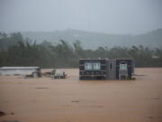 A home is submerged in floodwaters caused by Hurricane Fiona in Cayey, Puerto Rico, Sunday, Sept. 18, 2022.  According to authorities three people were inside the home and were reported to have been rescued.