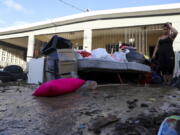 A woman looks at her water-damaged belongings after flooding caused by Hurricane Fiona tore through her home in Toa Baja, Puerto Rico, Tuesday, Sept. 20, 2022.