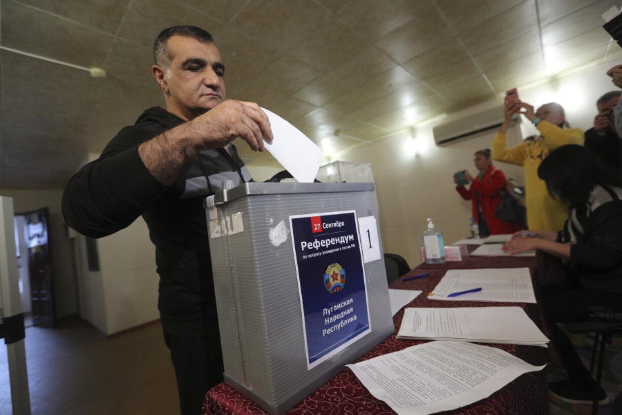 A man from Luhansk region, the territory controlled by a pro-Russia separatist government, but who lives in Russia, votes at temporary accommodation facility in Volgograd, Russia, Friday, Sept. 23, 2022. Voting began Friday in four Moscow-held regions of Ukraine on referendums to become part of Russia. Polls also opened in Russia, where refugees from regions under Russian control can cast their votes.