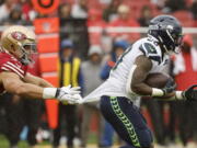 San Francisco 49ers defensive end Nick Bosa, left, grabs the jersey of Seattle Seahawks running back Rashaad Penny during the second half of an NFL football game in Santa Clara, Calif., Sunday, Sept. 18, 2022.