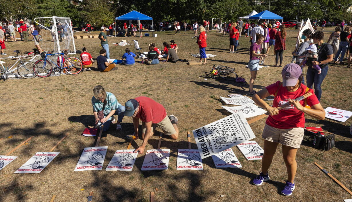 Seattle teachers make signs at Judkins Park Monday, Sept. 5, 2022 in advance of a possible strike this week. Teachers in Seattle have overwhelmingly voted to authorize a strike as contract talks continue on the eve of the new school year. Seattle Education Association President Jennifer Matter announced Tuesday that 95% of ballots returned by the union's membership favored going on strike absent an agreement with Seattle Public Schools.