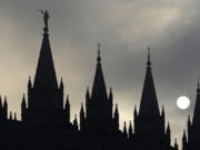 The angel Moroni statue atop the Salt Lake Temple is silhouetted against a cloud-covered sky at Temple Square in Salt Lake City in 2013. The Latter-day Saints have announced plans to build multiple temples in the U.S. — including one in Vancouver.