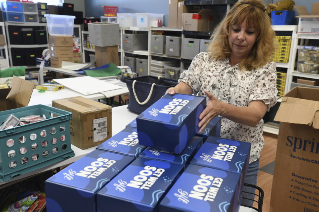 Kim Shanahan, who operates online store Gifts Fulfilled, stacks Get Well Soon boxes in her shop, Thursday, Sept. 8, 2022, in Berlin, Md. This is a fulfillment project for another company to create jobs at her company.