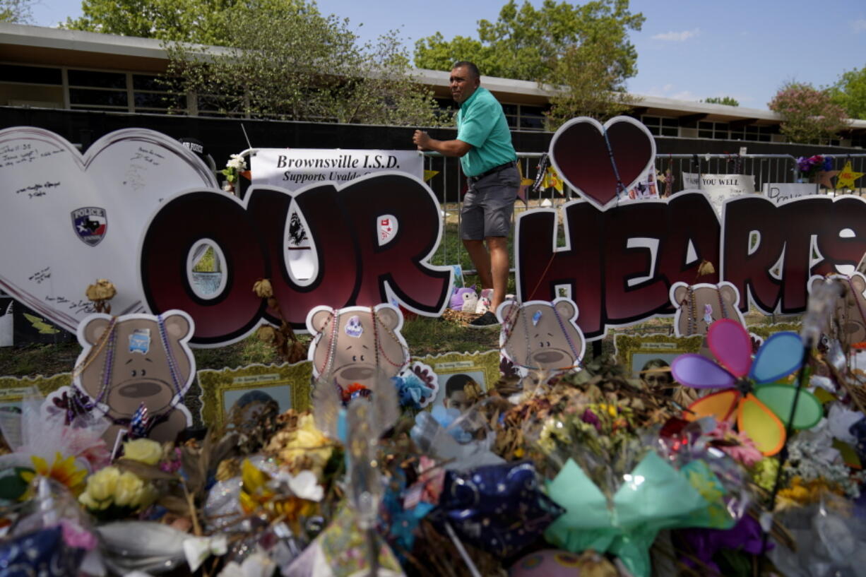 Brownsville school superintendent Dr. Rene Gutierrez adds a banner to a make-shift memorial that honor the victims of the school shootings at Robb Elementary, Tuesday, July 12, 2022, in Uvalde, Texas.