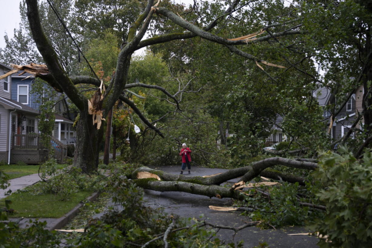 Georgina Scott surveys the damage on her street in Halifax as post tropical storm Fiona continues to batter the area on Saturday, Sept. 24, 2022.  Strong rains and winds lashed the Atlantic Canada region as Fiona closed in early Saturday as a big, powerful post-tropical cyclone, and Canadian forecasters warned it could be one of the most severe storms in the country's history.