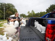 Victoria Colson, 31, of Tampa loads sandbags into her truck along with other Tampa residents who waited for over 2 hours at Himes Avenue Complex to fill their 10 free sandbags on Sunday, Sept. 25, 2022, in Tampa, Fla.