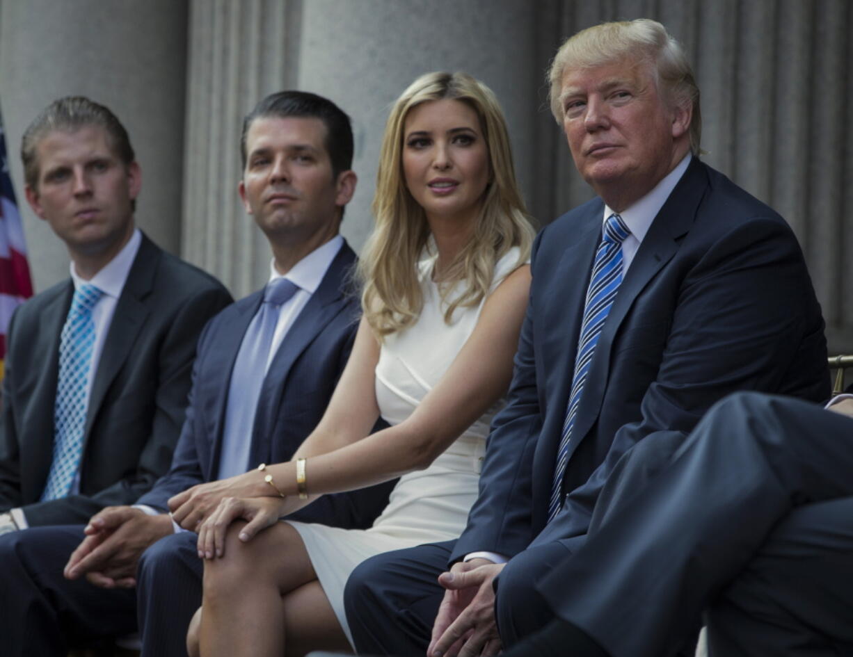 FILE - Donald Trump, right, sits with his children, from left, Eric Trump, Donald Trump Jr., and Ivanka Trump during a groundbreaking ceremony for the Trump International Hotel on July 23, 2014, in Washington. New York's attorney general sued former President Donald Trump and his company on Wednesday, Sept. 21, 2022, alleging business fraud involving some of their most prized assets, including properties in Manhattan, Chicago and Washington, D.C.