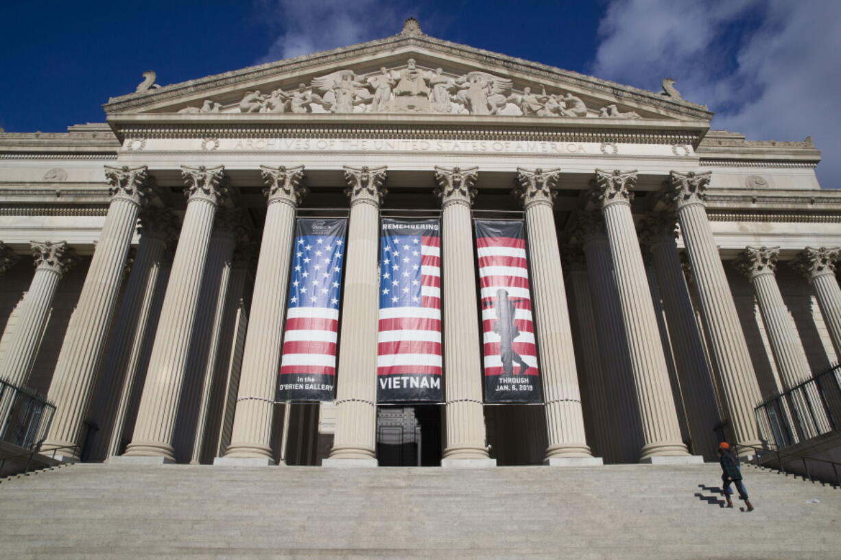 A person walks up the steps of the National Archives in Washington on Dec. 22, 2018. Its sprawling collection includes 13 billion pages of text and 10 million maps, charts and drawings, as well as millions of photographs, films and other records.