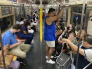 FILE -- Commuters wear face masks while riding the subway in New York, June 6, 2021. New York state is dropping its mask requirement on public transportation thanks in part to the availability of new booster shots targeting the most common strain of COVID-19, Gov. Kathy Hochul announced Wednesday, Sept. 7, 2022.