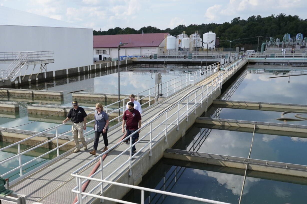 Jim Craig, with the Mississippi State Department of Health, left, leads Jackson Mayor Chokwe Antar Lumumba, right, Deanne Criswell, administrator of the Federal Emergency Management Agency (FEMA), center, and Mississippi Gov. Tate Reeves, rear, as they walk past sedimentation basins at the City of Jackson's O.B. Curtis Water Treatment Facility in Ridgeland, Miss., Friday, Sept. 2, 2022. Jackson's water system partially failed following flooding and heavy rainfall that exacerbated longstanding problems in one of two water-treatment plants. (AP Photo/Rogelio V.