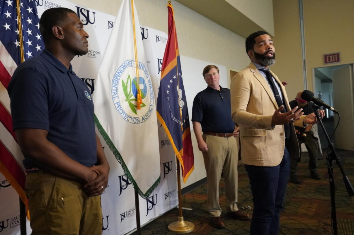 Jackson Mayor Chokwe Antar Lumumba discusses elements of a coordinated response with federal agencies, that he believes will help deal with the city's long-standing water problems, during a Wednesday, Sept. 7, 2022, news briefing, in Jackson, Miss. Lumumba also conferred with Environmental Protection Agency Administrator Michael S. Regan, left, and Mississippi Gov. Tate Reeves, background, and other officials to explore options. (AP Photo/Rogelio V.