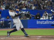 New York Yankees' Aaron Judge hits a two-run home run, his 61st homer of the season, during the seventh inning of the team's baseball game against the Toronto Blue Jays on Wednesday, Sept. 28, 2022, in Toronto.