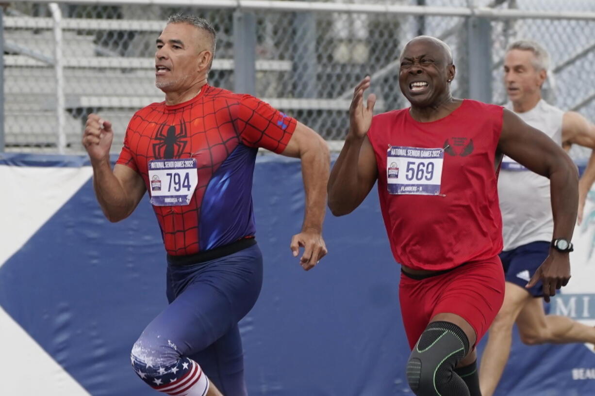 Anthony Hinojosa of California sprints to the finish line as Ronald Flanders of North Carolina attempts to catch up during the final 200 meter race for men over 65 at the National Senior Games.