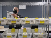 Election board worker Chuck Perine prepares ballots to be recounted at the Clark County Elections Office on Nov. 29, 2021.