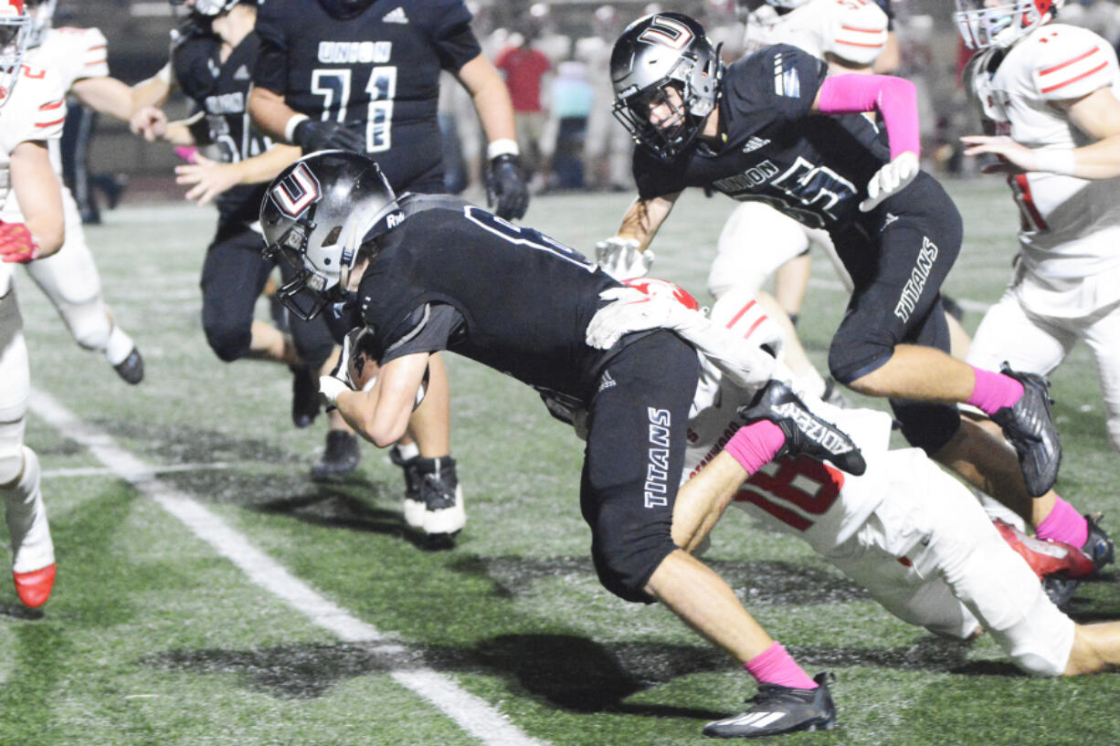 Union's Chase Lofton is brought down by Stanwood's Max Mayo during Union's 69-47 loss to Stanwood at McKenzie Stadium on Friday, Oct. 7, 2022.