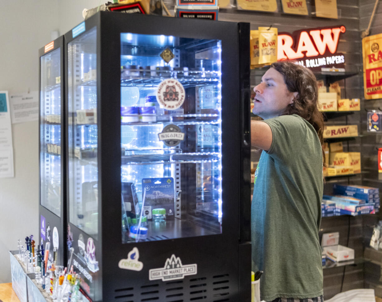 High End Marketplace business manager Jeffrey Hickok looks through a display case at the dispensary in Vancouver.