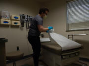 Medical assistant Daniel Salazar cleans an examination room between patients Sept. 28 at the Free Clinic of Southwest Washington. The clinic, on Plomondon Road, offers free health care for those without insurance and advocacy for those with limited English language skills.