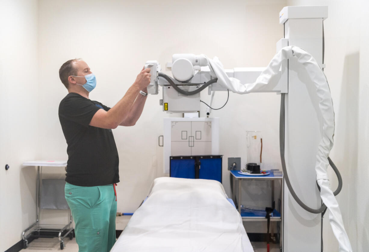 Physician assistant and Vital Care owner Todd Cichosz adjusts an X-ray machine at the new primary and urgent care clinic in Battle Ground.