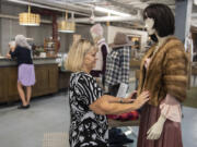 Volunteer Donna Jeffries works on a display at b.divine clothing boutique.