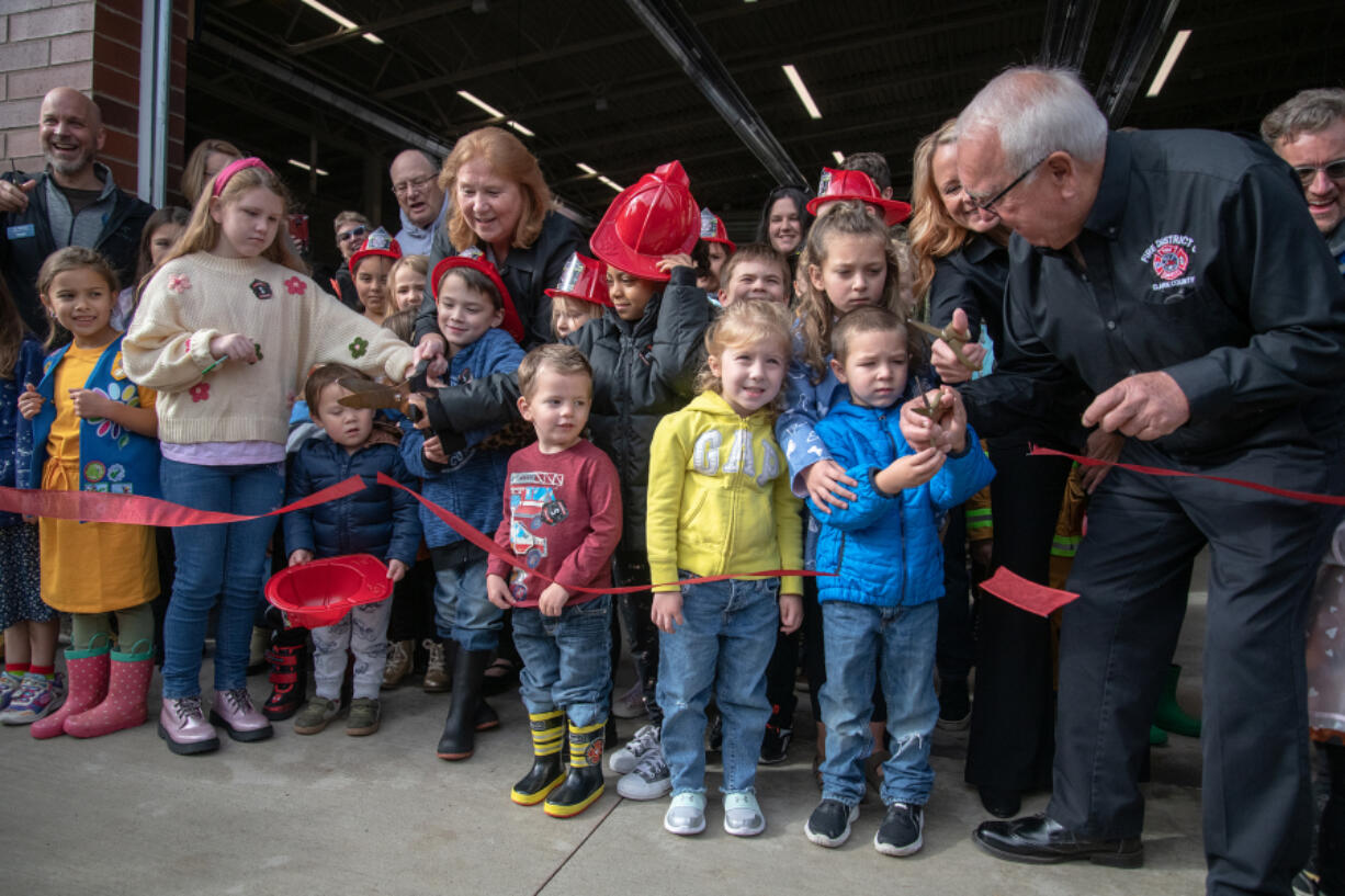 Local children help Vancouver and Clark County officials cut the ceremonial ribbon at Saturday's grand opening for the city's new Fire Station 11.