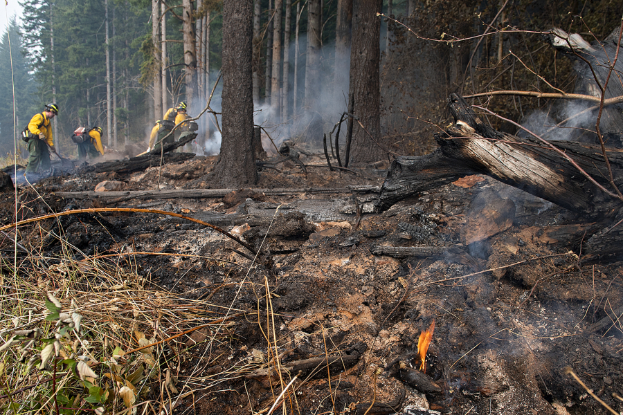 A small flame burns in the Camas Creek watershed while firefighters tackle the Nakia Fire in October 2022.