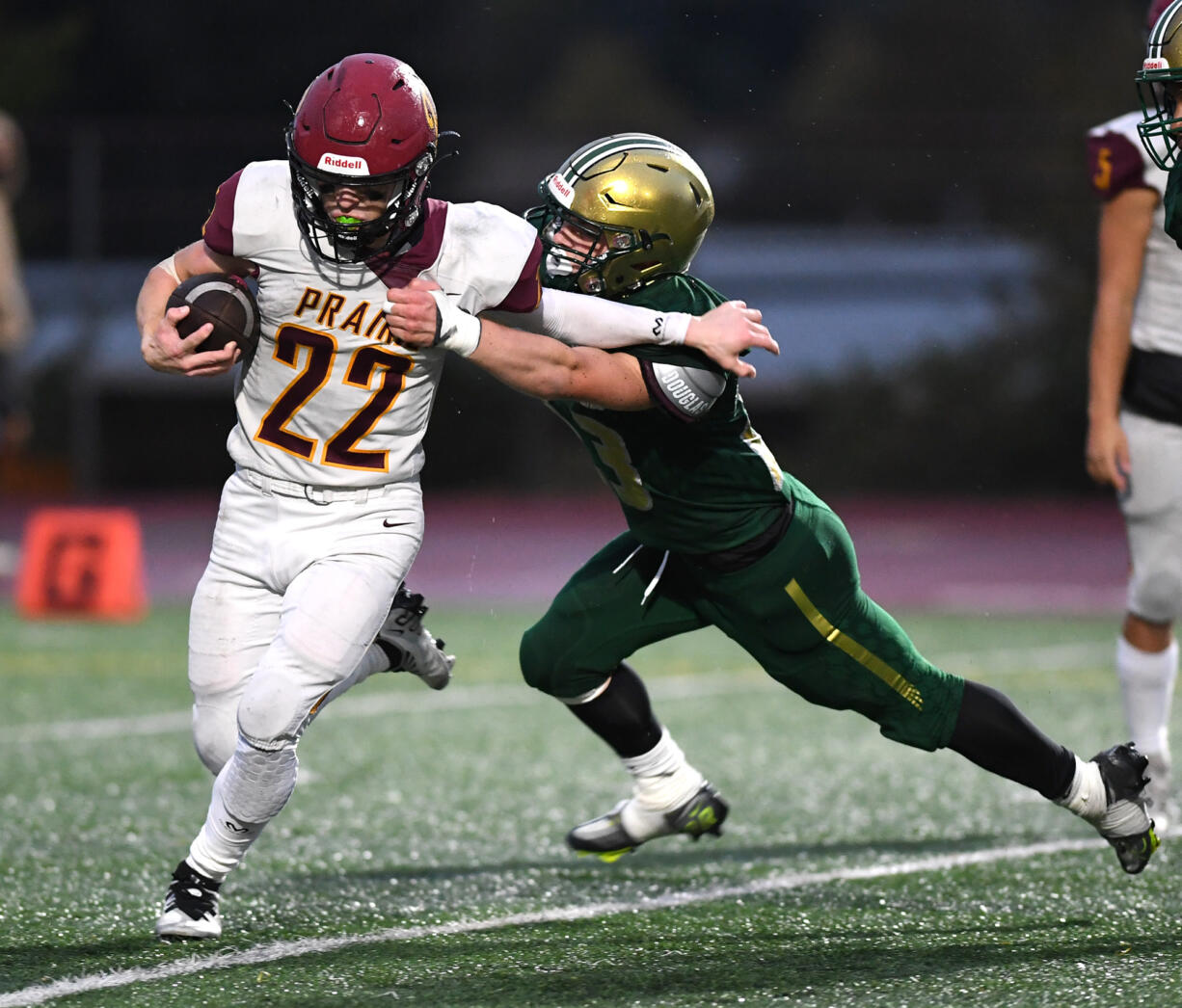 Prairie sophomore Preston Hill, left, stiff arms Evergreen senior Jaxon Morris on Friday, Oct. 21, 2022, during the Falcons’ 13-6 win against Evergreen at McKenzie Stadium.