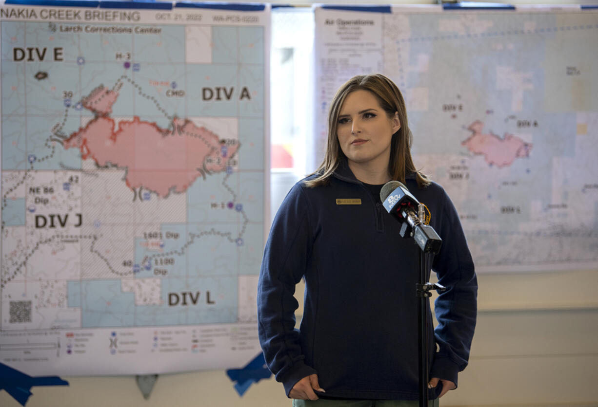 Fire Information Officer Natalie Weber speaks to members of the media Friday. A map showing the updated boundaries of the Nakia Creek Fire hangs behind her.