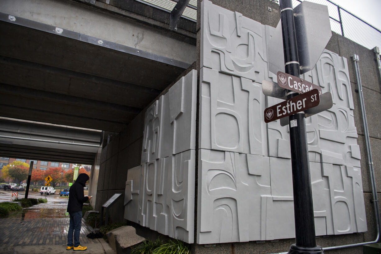 Above, Mayor Pro Tem Ty Stober looks over an informational panel about artist James Lee Hansen after he unveiled his latest 34-panel installation at the corner of Esther and Cascade streets on Friday. The collection of 5-by-5-foot squares on the underpass in downtown Vancouver were salvaged from the Clark County Title Company Building before it was demolished in 2019.