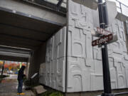 Above, Mayor Pro Tem Ty Stober looks over an informational panel about artist James Lee Hansen after he unveiled his latest 34-panel installation at the corner of Esther and Cascade streets on Friday. The collection of 5-by-5-foot squares on the underpass in downtown Vancouver were salvaged from the Clark County Title Company Building before it was demolished in 2019.