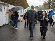 Gov. Jay Inslee, left, strolls with Vancouver's Homeless Response Coordinator Jamie Spinelli during a tour of the Outpost Safe Stay Community Monday morning. Officials are hailing it as a possible model for other cities to address the needs of the unhoused.